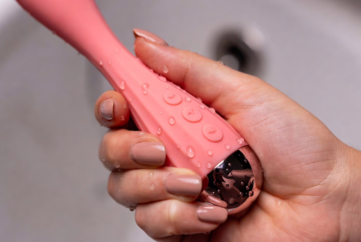Close-up of waterproof vibrator controls and textured grip with water droplets